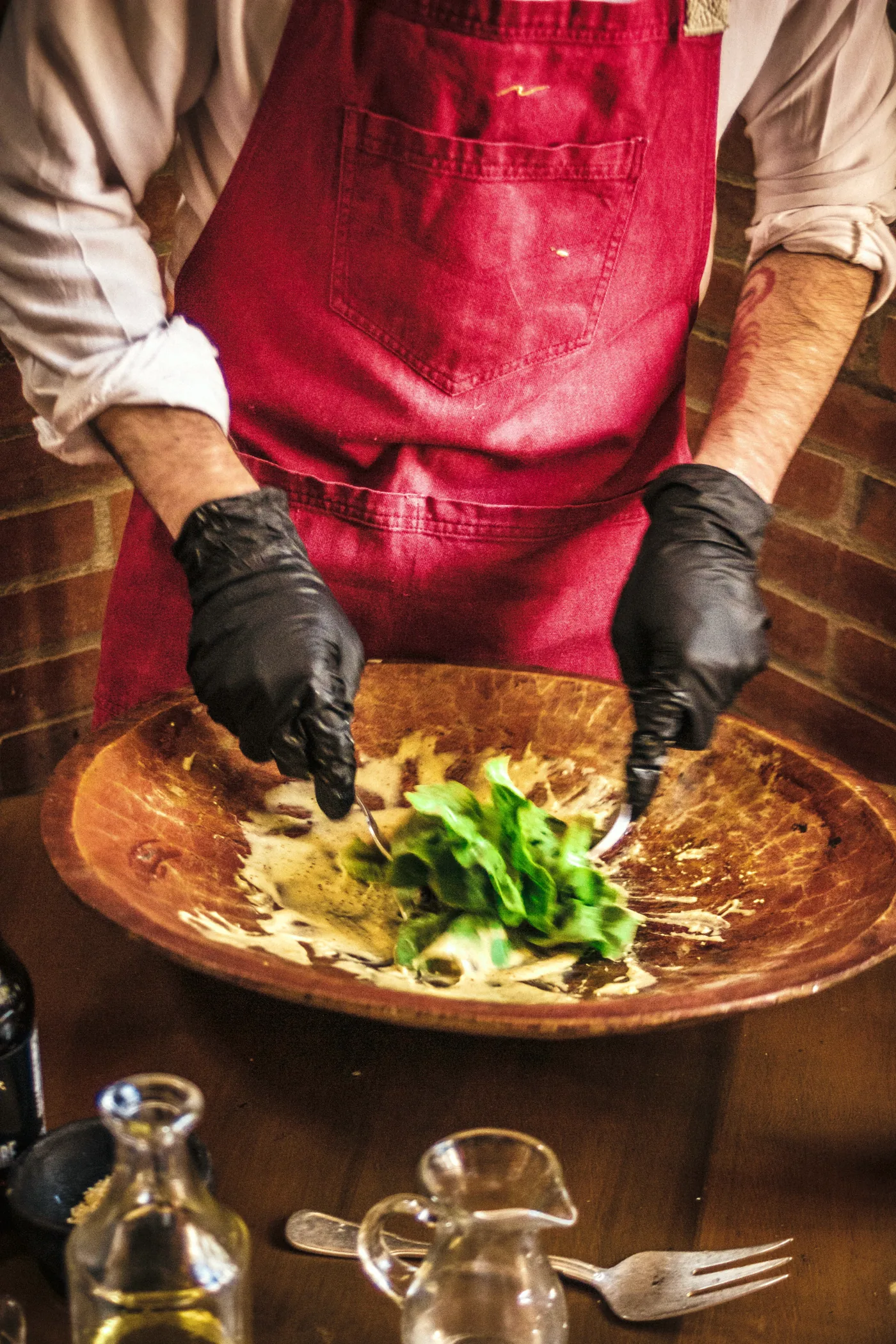 Ensalada César preparada en mesa en bowl de madera