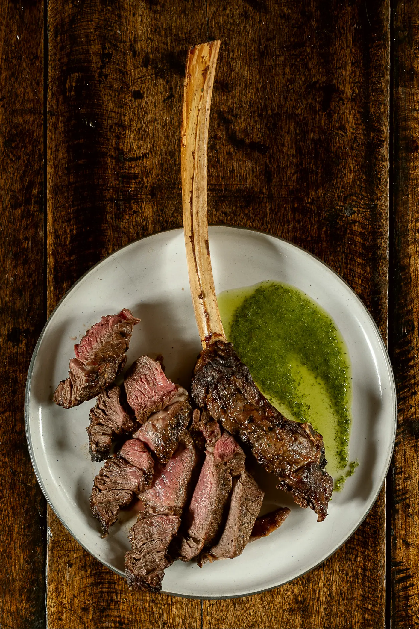 Tomahawk laminado con hueso largo y chimichurri de la casa